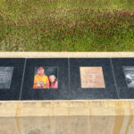 Memorial with photo of man named Dennis in front of flowery, tall grass at Eldridge Memorial
